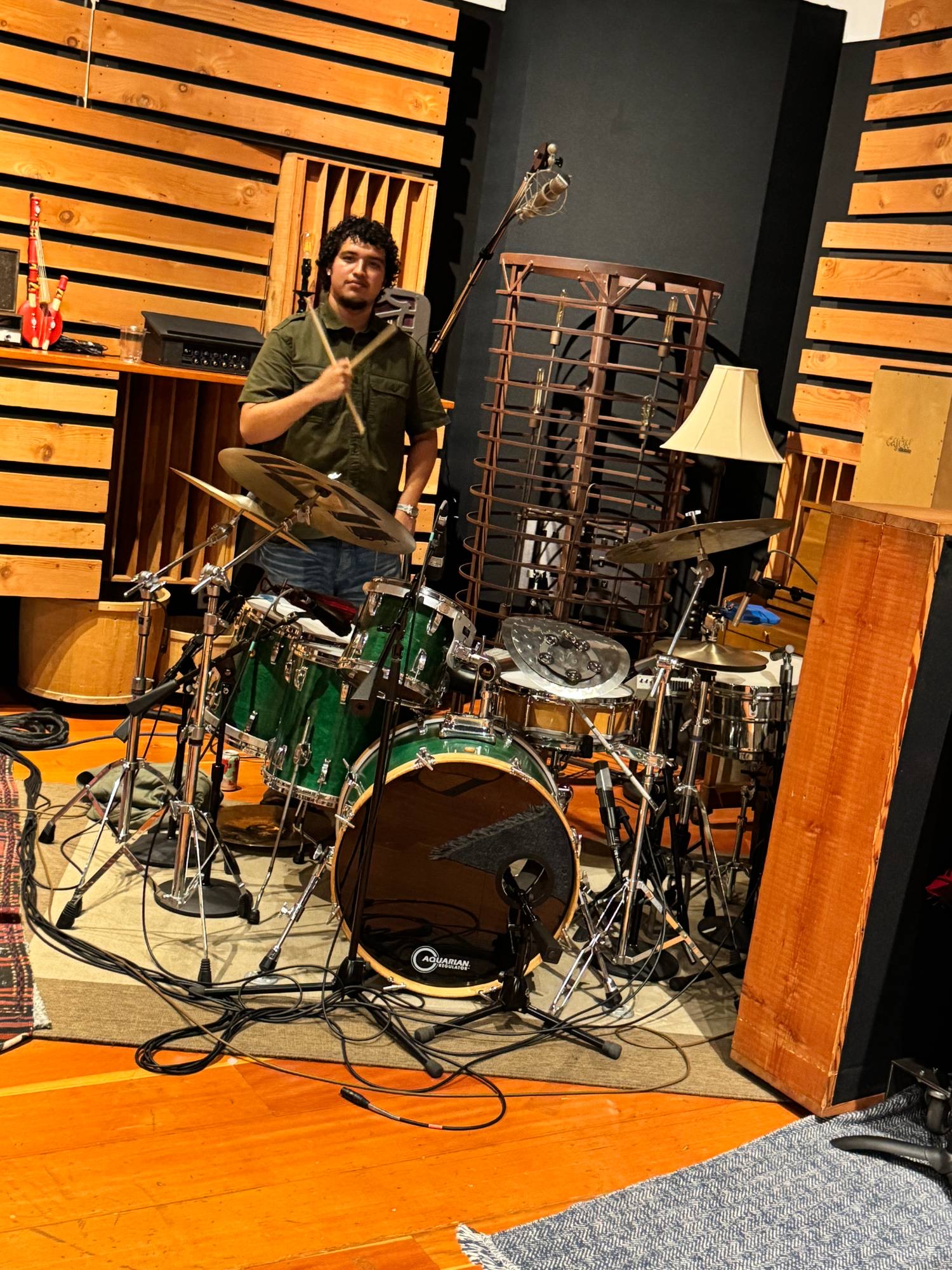 Joaquin behind the kit in the studio, sticks raised